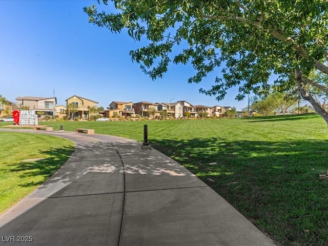 view of property's community with a residential view and a lawn