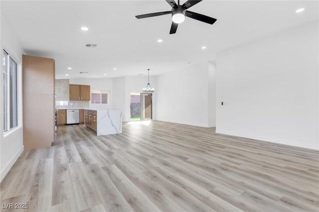 unfurnished living room with ceiling fan with notable chandelier and light wood-type flooring