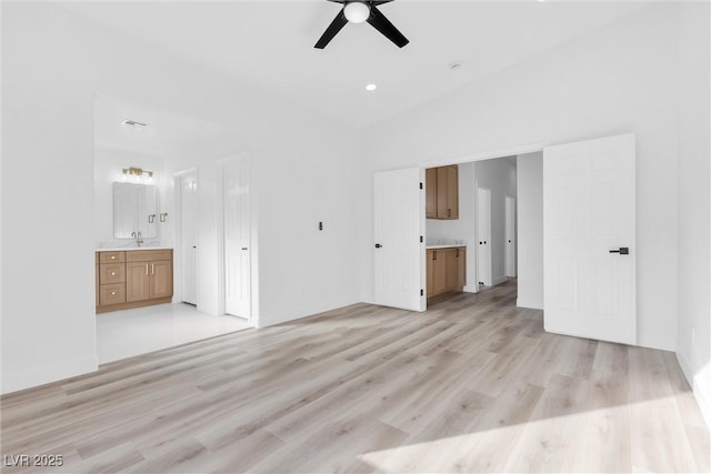 interior space with sink, vaulted ceiling, ceiling fan, and light wood-type flooring