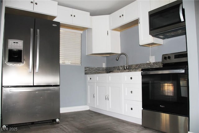 kitchen featuring dark stone countertops, dark parquet floors, white cabinets, and appliances with stainless steel finishes