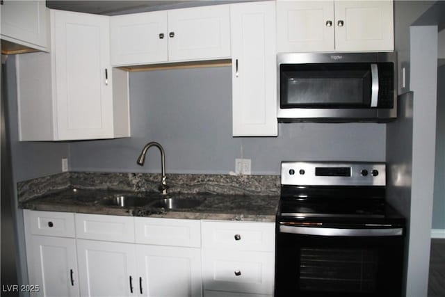 kitchen with dark stone countertops, black electric range oven, sink, and white cabinets