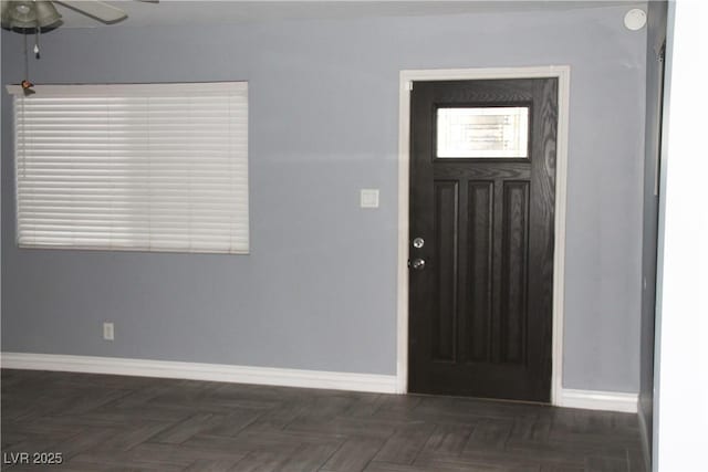 entryway featuring ceiling fan and dark parquet flooring