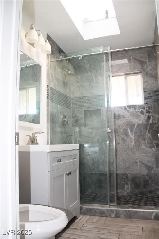 bathroom featuring vanity, a skylight, and walk in shower