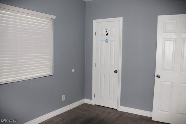 unfurnished bedroom featuring dark parquet flooring