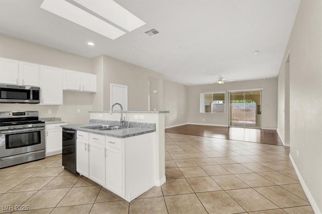 kitchen featuring white cabinets, appliances with stainless steel finishes, sink, and light tile patterned floors