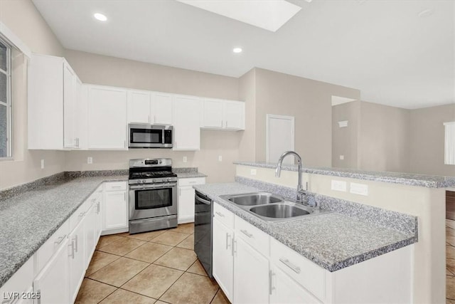 kitchen featuring sink, light tile patterned flooring, white cabinetry, stainless steel appliances, and a kitchen island with sink