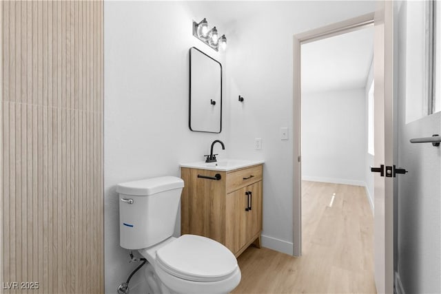 bathroom featuring wood-type flooring, toilet, and vanity