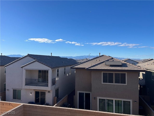 back of property featuring a balcony and a mountain view