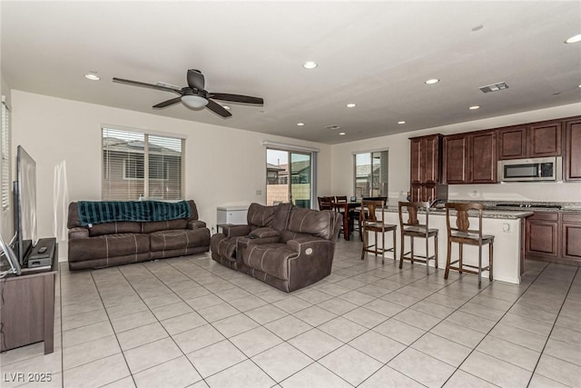 living room with light tile patterned floors and ceiling fan