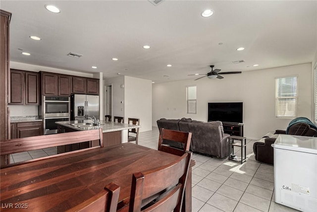 dining area with sink, ceiling fan, and light tile patterned flooring