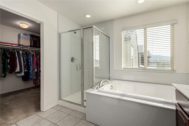 bathroom with tile patterned floors, plus walk in shower, and vanity