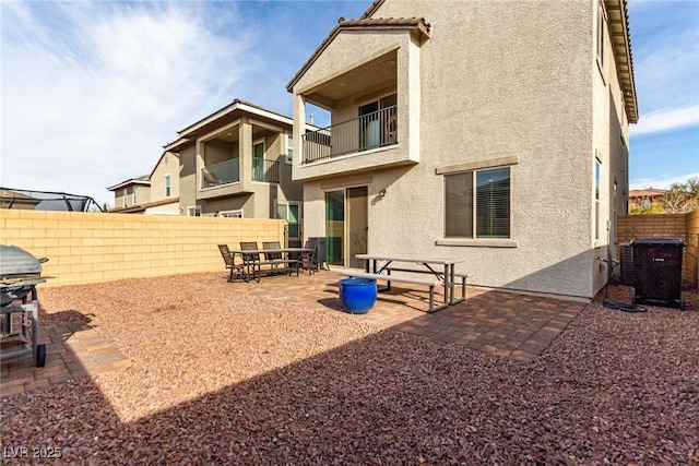 rear view of property with a balcony, a patio, and central air condition unit