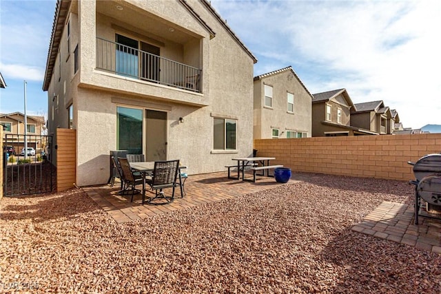 rear view of property with a patio and a balcony