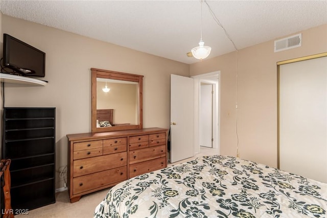 carpeted bedroom featuring a textured ceiling and a closet