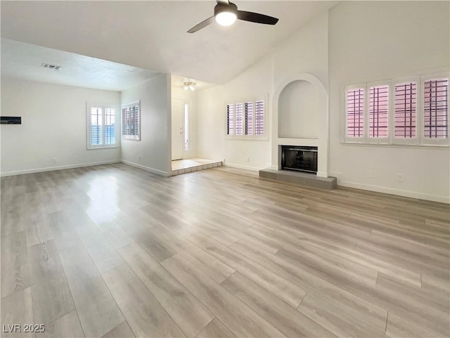 unfurnished living room with ceiling fan, vaulted ceiling, and light hardwood / wood-style flooring