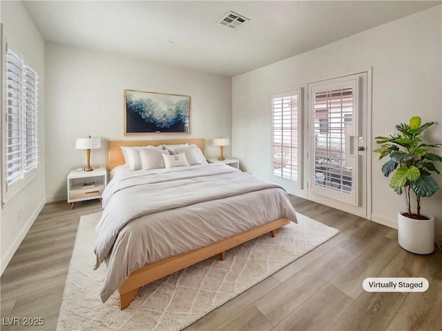 bedroom featuring access to exterior and hardwood / wood-style floors