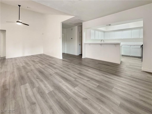 unfurnished living room featuring ceiling fan and light wood-type flooring