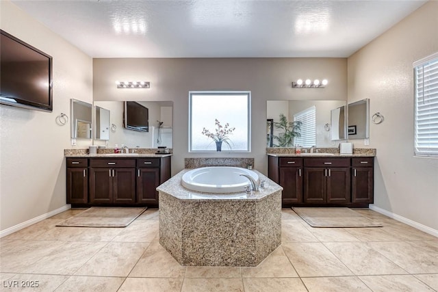 bathroom with vanity, tiled bath, and tile patterned flooring