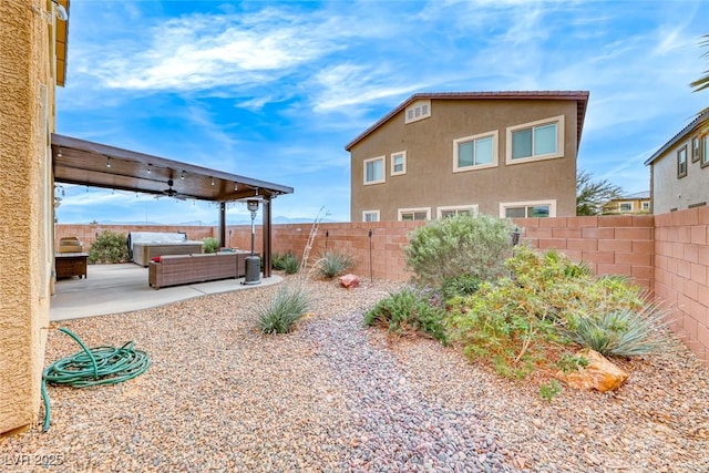 view of yard featuring ceiling fan, a hot tub, and a patio