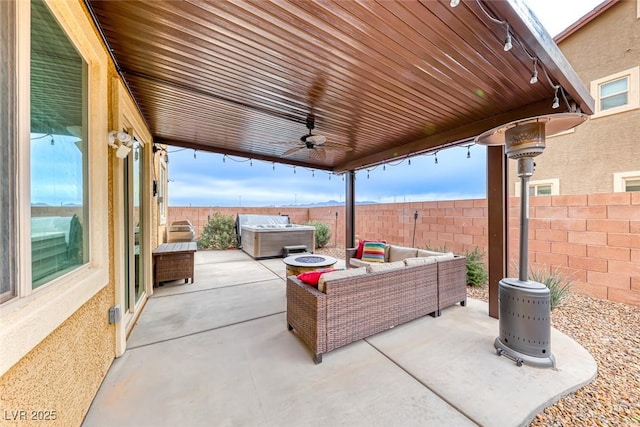 view of patio featuring a hot tub, an outdoor hangout area, and ceiling fan