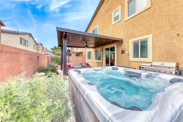 back of property with a hot tub, outdoor lounge area, and ceiling fan