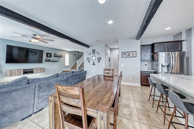 dining space featuring beamed ceiling, light tile patterned flooring, and ceiling fan