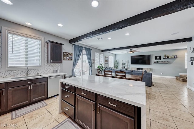 kitchen featuring sink, tasteful backsplash, a center island, dishwasher, and beam ceiling