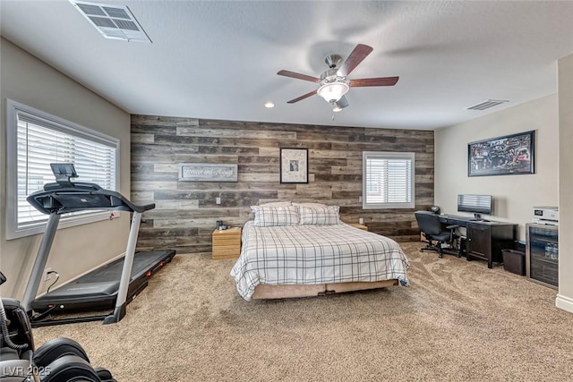 carpeted bedroom with wooden walls and ceiling fan