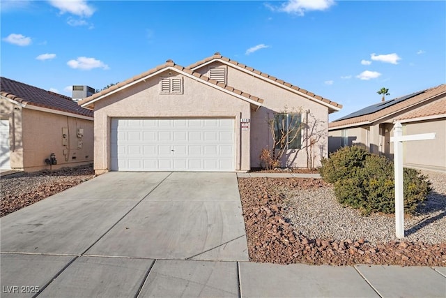 ranch-style home with concrete driveway, an attached garage, a tile roof, and stucco siding