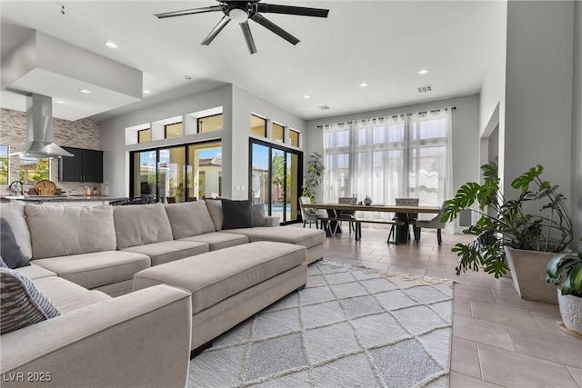 living room featuring light tile patterned flooring, plenty of natural light, sink, and ceiling fan