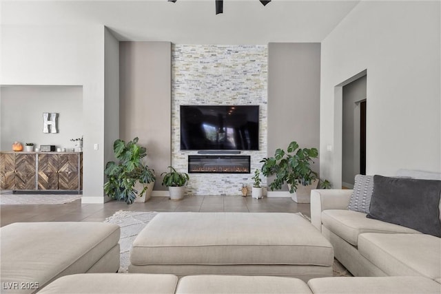 living room with a stone fireplace and ceiling fan