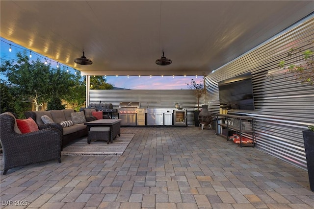 view of patio featuring a grill, an outdoor living space, and an outdoor kitchen