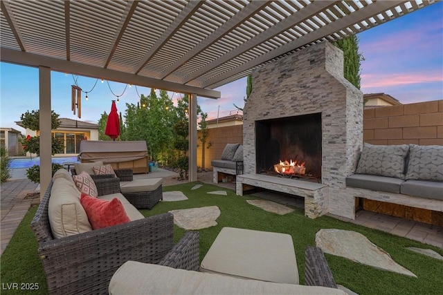 patio terrace at dusk featuring a grill, an outdoor living space with a fireplace, and a pergola