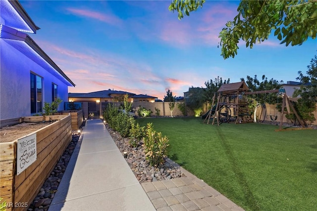 yard at dusk featuring a playground