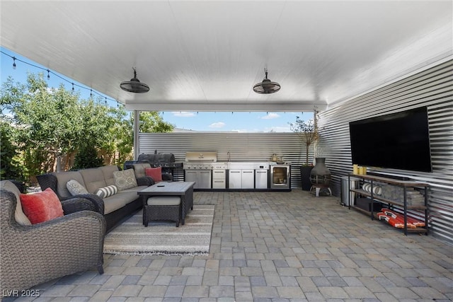 view of patio / terrace featuring sink, ceiling fan, outdoor lounge area, a grill, and exterior kitchen