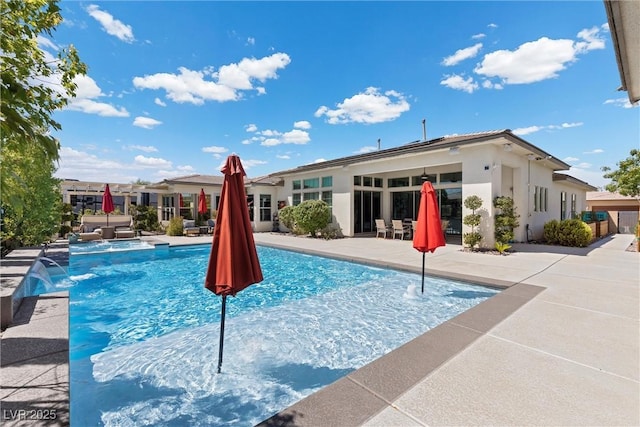 view of swimming pool with a patio area, pool water feature, and an in ground hot tub