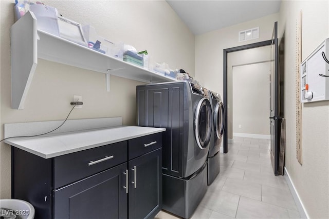 clothes washing area with light tile patterned floors and washing machine and dryer