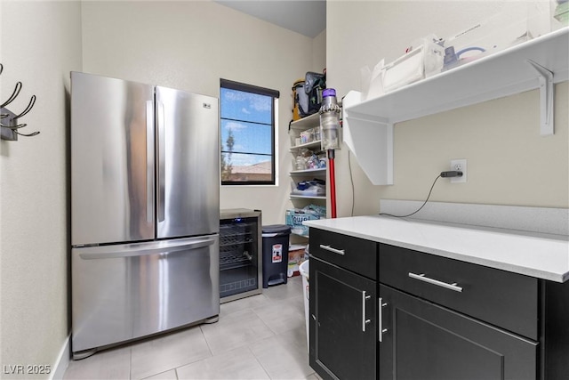 kitchen with wine cooler, light tile patterned floors, and stainless steel fridge