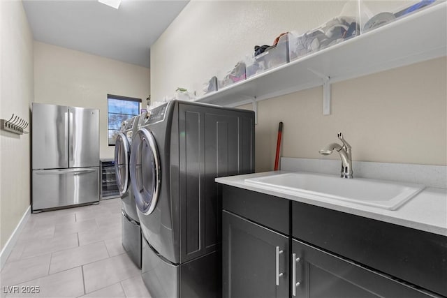 washroom featuring light tile patterned flooring, cabinets, sink, and washer and dryer