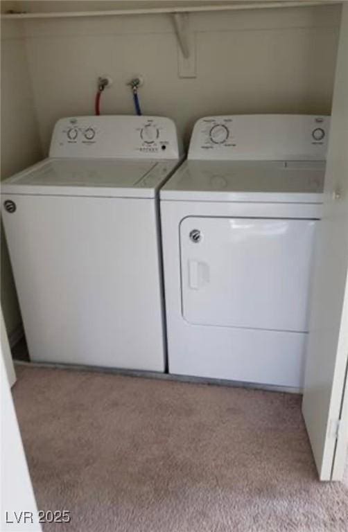 laundry area with light colored carpet and washer and dryer