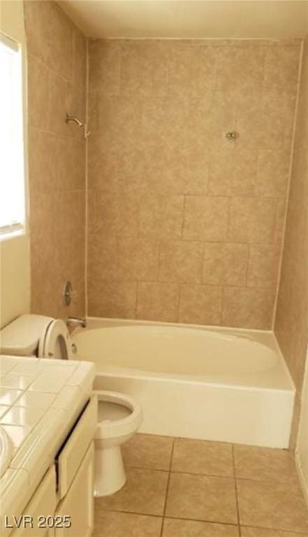 full bathroom featuring tile patterned floors, vanity, toilet, and tiled shower / bath combo