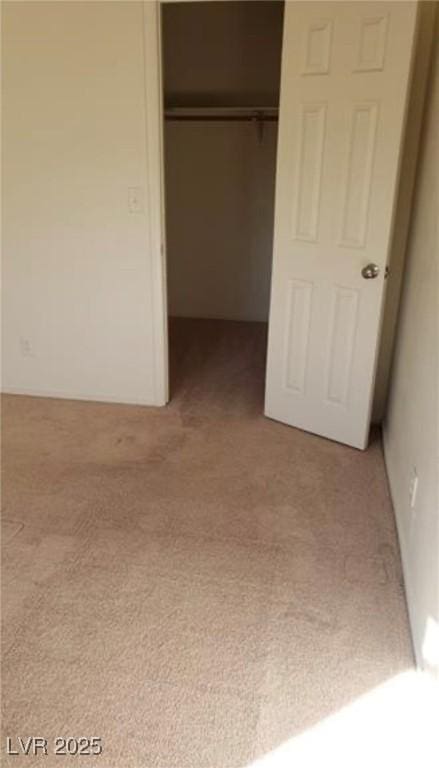 unfurnished bedroom featuring light colored carpet and a closet