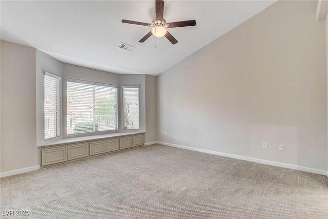 spare room with vaulted ceiling, light colored carpet, and ceiling fan