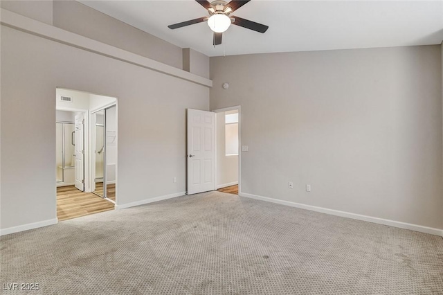 unfurnished bedroom with light carpet, a closet, ceiling fan, and ensuite bathroom