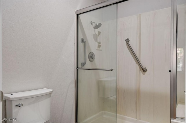 bathroom featuring an enclosed shower and toilet