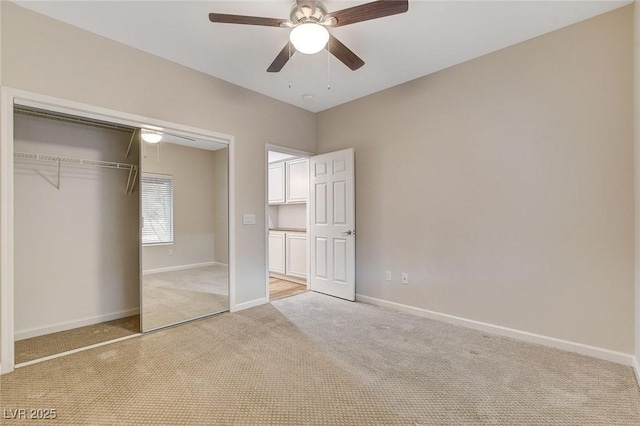 unfurnished bedroom with light colored carpet, a closet, and ceiling fan