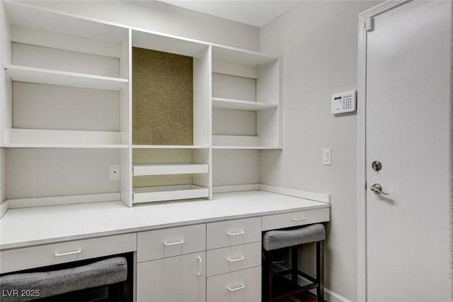 unfurnished office featuring wine cooler and built in desk