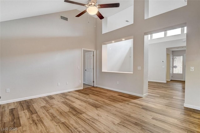 empty room featuring ceiling fan, high vaulted ceiling, and light hardwood / wood-style flooring