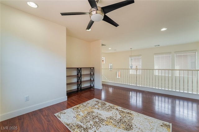 spare room featuring recessed lighting, wood finished floors, a ceiling fan, and baseboards