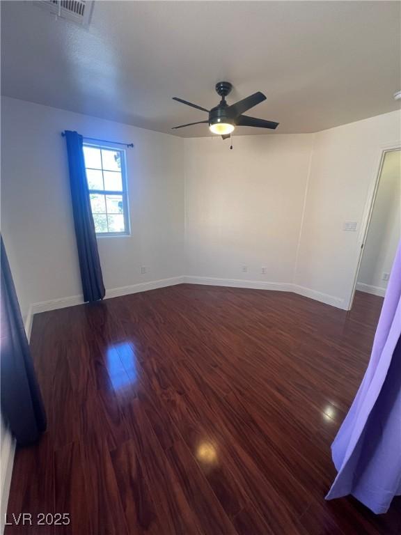 unfurnished room with wood finished floors, visible vents, baseboards, and ceiling fan